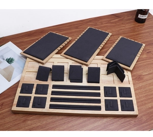 Detailed top view of wooden jewelry display set with black velvet necklace and ring inserts