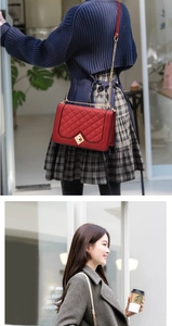 Detail of red quilted chain bag with gold hardware worn as a shoulder bag