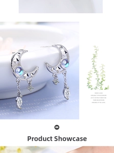 Macro shot of silver moon earrings with blue moonstone and celestial charms on a white bowl