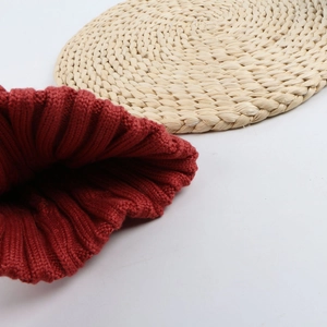 Close-up detail of reddish brown chunky ribbed knit winter beanie hat texture
