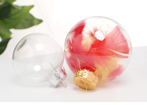 Detail of transparent PET Christmas bauble filled with vibrant red and yellow feathers