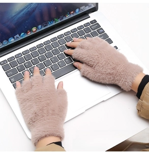 Mitaines douillettes en fausse fourrure rose poudré utilisées sur un clavier