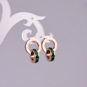 Detail of rose gold double ring earrings with Roman numerals and green zircon stones
