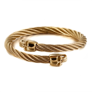 Punk Herren Armreif aus goldenem Edelstahl mit Totenkopf-Design auf weißem Hintergrund