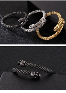 Detailansicht von drei geflochtenen Totenkopf-Armspangen in Schwarz, Silber und Gold
