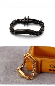 Detail of Byzantine chain link bracelet with cross charm in black and gold finishes