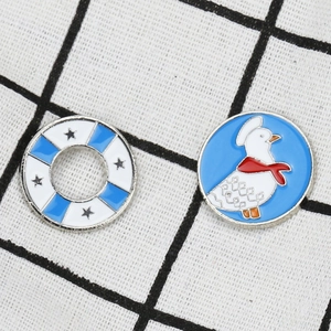Detailed view of nautical lifebuoy and cartoon duck pins on black and white checkered fabric