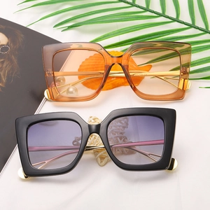 Oversized square sunglasses in amber and black frames with gradient lenses and metal temples