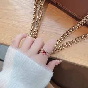 Detail of red heart zircon ring and colorful crystal band on hand with cozy background