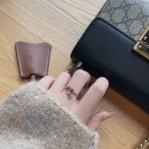 Detail of rose gold ring featuring a heart-shaped purple stone and dangling crystal