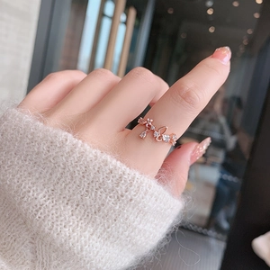 Detailed view of rose gold floral butterfly ring with crystals worn on index finger