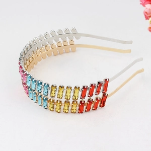 Close-up of gold and silver headbands with colorful rectangular rhinestones on white background