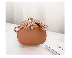Détails d'un sac seau en cuir PU marron avec gaufrage en cœur et pompons décoratifs