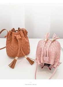 Détail de sacs seaux à cordon avec gaufrage à pois texturé et finitions à glands élégants