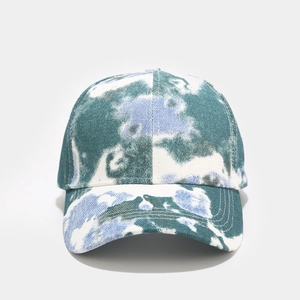 Détail d'une casquette tie-dye bleue et verte avec double couture renforcée sur la visière
