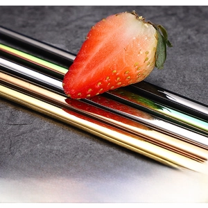 Close-up of mirror polished stainless steel straws in multiple colors on a stone surface