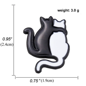 Enamel lapel pin featuring two hugging black and white cats, dimensions 2.4cm by 1.9cm