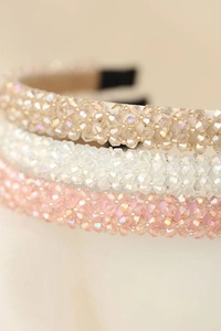 Close-up of beaded headbands featuring sparkling champagne, holographic and pink crystals