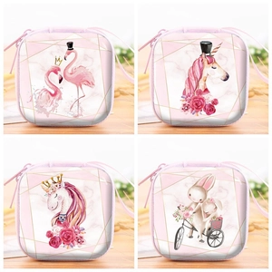 Close-up of four pink tinplate coin purses with unicorn and flamingo illustrations