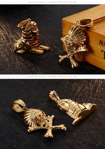 Detailansicht von goldenen Sphinx- und Schädel-Anhängern aus Edelstahl auf einer Holzbox