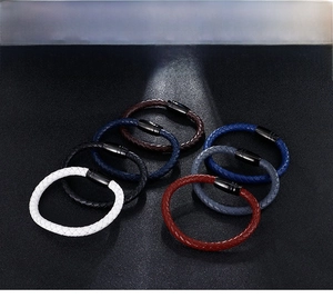 Set of six colorful braided leather bracelets with metallic magnetic clasps on dark surface