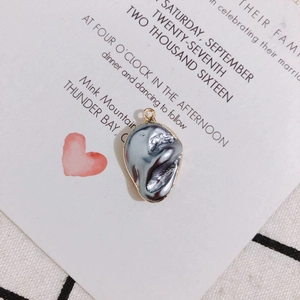 Macro detail of irregular baroque grey pearl pendant with elegant gold plated edge