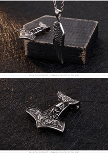 Detail of vintage Viking Mjolnir pendant and crow wing with antique silver finish necklace