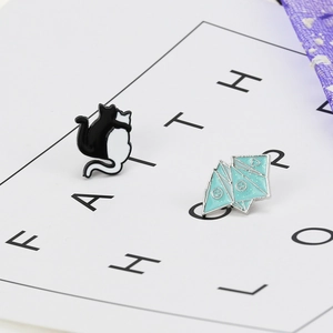 Detail of blue origami and black white cat enamel pins on faith card background