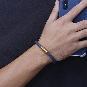 Men's grey braided leather bracelet with a gold-colored threaded metal buckle