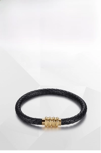 Detail of black woven leather bracelet with textured gold stainless steel magnetic clasp
