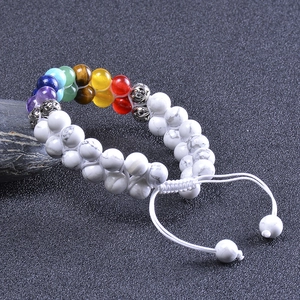 Close-up of double-layer turquoise beaded bracelet with chakra stones on black stone