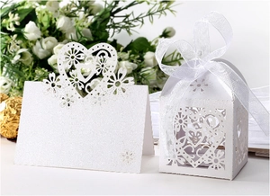Detail of laser-cut white favor box with heart patterns and elegant organza ribbon