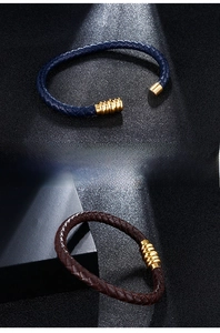 Detail of woven leather bracelets with gold magnetic clasps in navy and brown leather