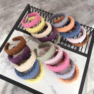 Detail of plush velvet padded headbands in various vibrant colors on a textured display