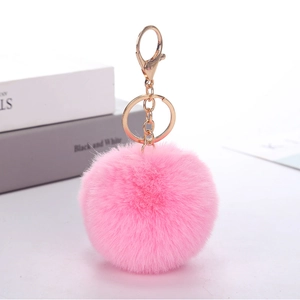 Detailed view of a soft pink faux rabbit fur pom pom keychain with a gold metal clasp