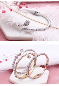Gros plan de trois bracelets serpent en or, argent et or rose avec sertissage en pavé