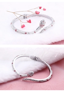 Détail du bracelet serpent argenté orné de strass roses et blancs sur soie et fourrure