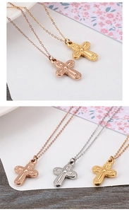 Detailed view of cross pendant necklaces in rose gold, gold, and silver finishes
