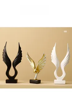 Detailed view of abstract resin angel wing sculptures in black, gold, and white finishes