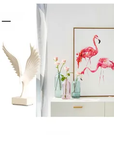 Close-up of modern white resin angel wings sculpture on a sleek rectangular base