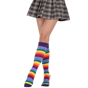 Detailed close-up of colorful rainbow striped knee-high socks on a model with a plaid skirt