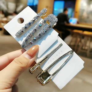Détail d'un ensemble de quatre barrettes à cheveux avec strass et épingles en métal
