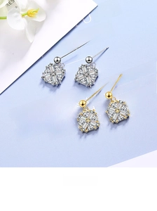 Detailed view of square and round zircon stud earrings in silver and gold finishes