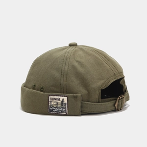 Detail of adjustable metal buckle and vintage side patch on military green docker hat