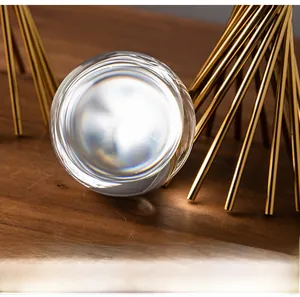 Detailed close-up of a clear crystal ball ornament with a golden geometric metal base