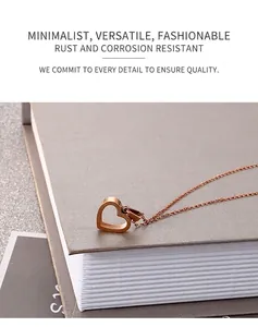 Detailed close-up of a rose gold hollow heart pendant necklace on a textured book
