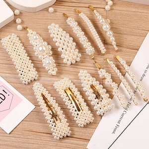 Flat lay of 12-piece pearl hair clip set with gold alloy base on wooden surface