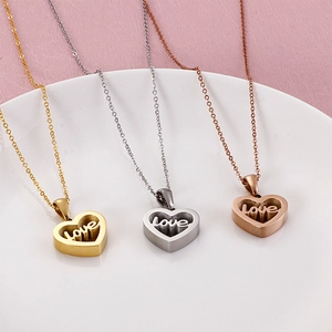 Three heart-shaped love necklaces in gold, silver, and rose gold on a ceramic plate