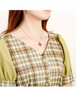 Gros plan du collier avec pendentif cœur doré porté sur le cou d'un mannequin