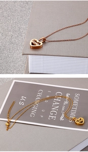 Détail macro du pendentif cœur avec gravure love et chaîne dorée ajustable